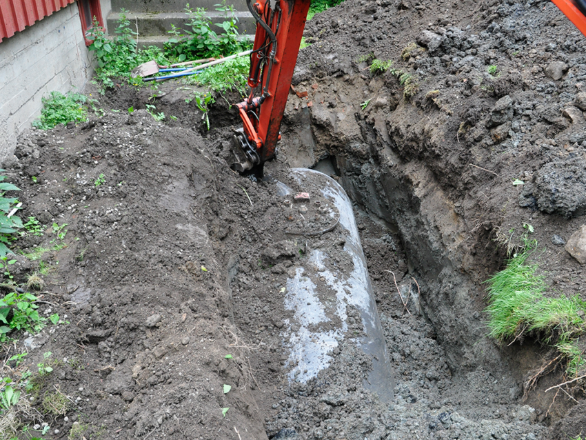 gravemaskin som graver opp tank. Foto.