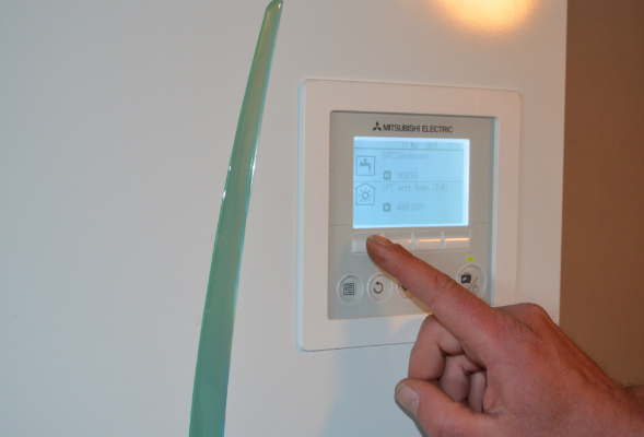 Person som trykker på Ecodan-display. Foto.