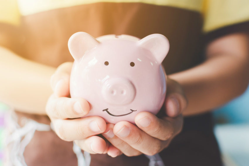 Person holder sparegris. Foto.