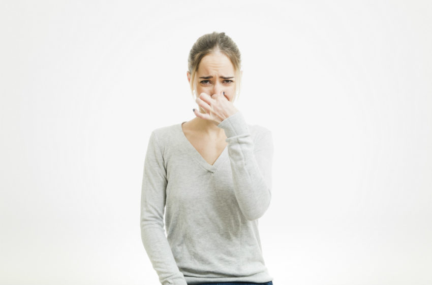 Dame som holder seg for nesen .Foto.