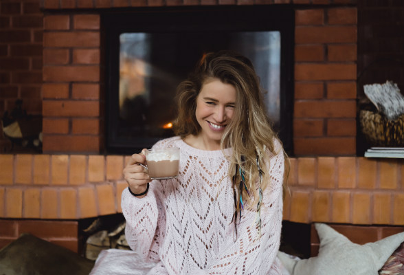 Dame koser seg med kakaokopp. Foto.