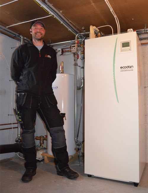 Montør ved siden av Ecodan innedel. Foto.