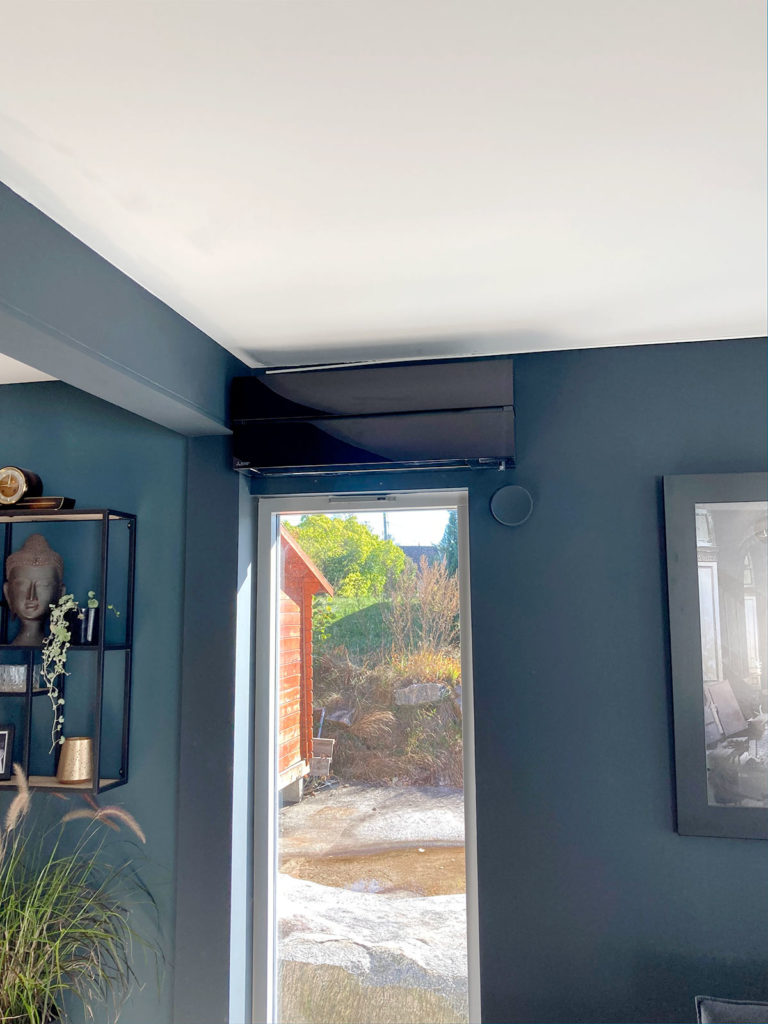 Svart varmepumpe, innedel, monter på vegg. Foto.